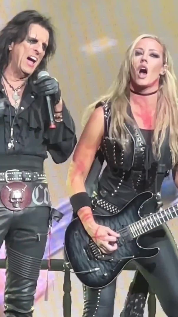 Nita Strauss tearing it up while Alice Cooper watches like a proud villain